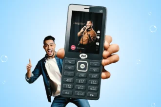 "एक यूथ AI फीचर फोन itel Super Guru 4G Max के साथ पोज़ करते हुए, जिसमें बड़ी डिस्प्ले पर वीडियो कंटेंट चल रहा है – फोन में 4G, वॉइस कमांड और AI बटन दिख रहा है।